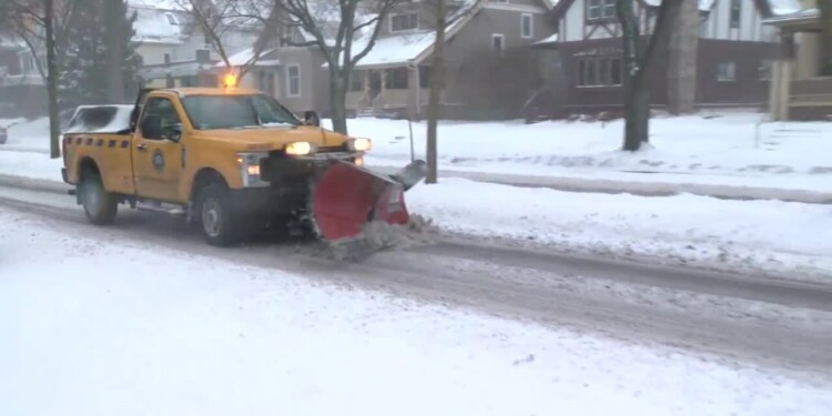 A city snow plow truck clearing a road of snow