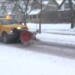 A city snow plow truck clearing a road of snow