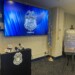 A podium and screen featuring the Milwaukee Police Seal as well as a poster board with Operation North Star III as well as statistics on crime printed on it,