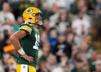 Aaron Rodgers of the Green Bay Packers wears a coat to stay warm in News  Photo - Getty Images