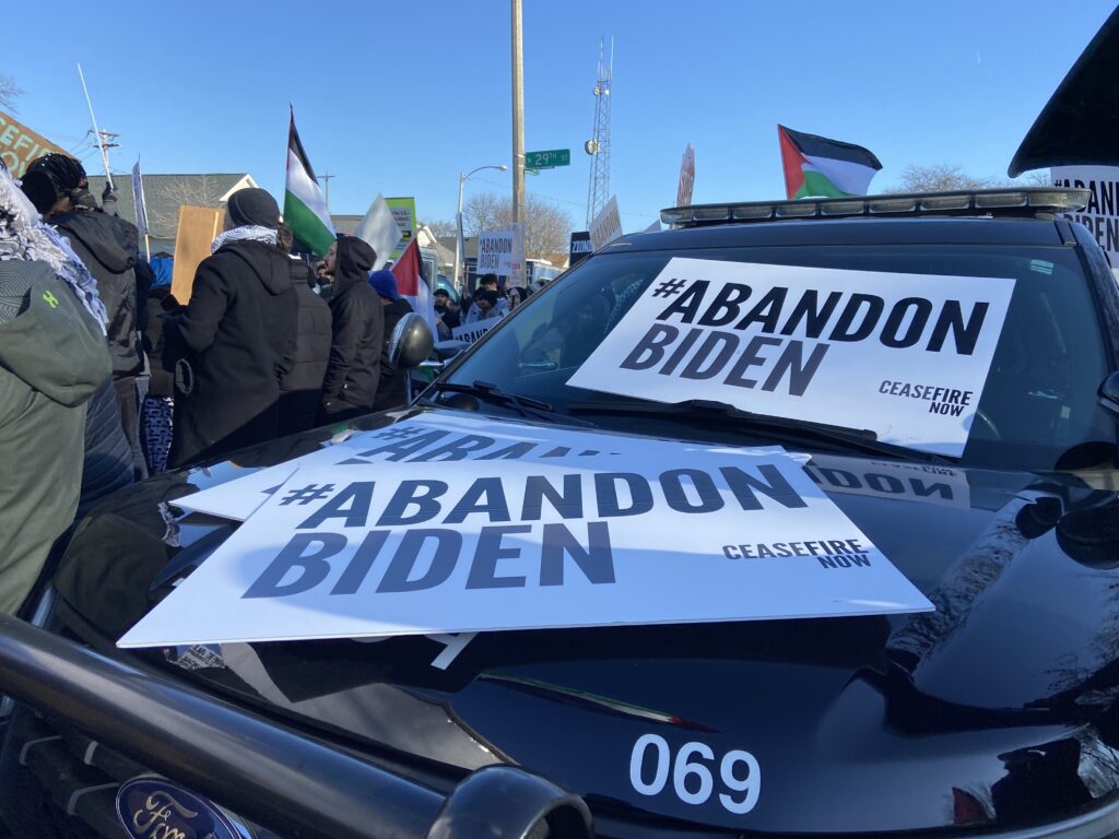 Signs that say #AbandonBiden laid out on the hood and windshield of a Milwaukee Police Department SUV