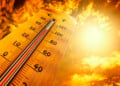 Thermometer showing tropical heat and sky with hot sun rays in Celsius and Fahrenheit