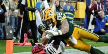 Green Bay Packers tight end Tucker Kraft (85) scores a touchdown againmst Cincinnati Bengals safety Jordan Battle (27) in the second half of an NFL football game, Sunday, Oct. 12, 2025, in Green Bay, Wis. (AP Photo/Morry Gash