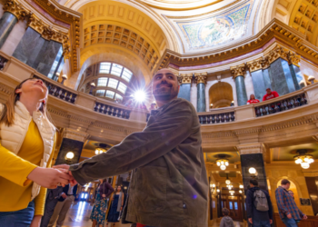 Couple holds hands in the center of the Wisconsin State Capitol Building in Madison (Photo: Travel Wisconsin)