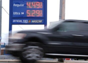 A vehicle passes a gasoline price board at a filling station in Philadelphia, Friday, March 27, 2026. (AP Photo/Matt Rourke)