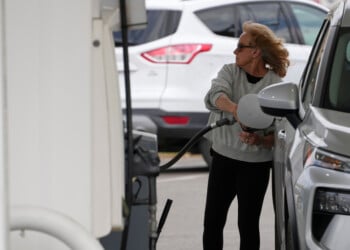 A woman fills her vehicle with fuel at a gas station, Monday, March 30, 2026, in Nashville, Tenn. (AP Photo/George Walker IV)