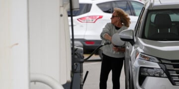 A woman fills her vehicle with fuel at a gas station, Monday, March 30, 2026, in Nashville, Tenn. (AP Photo/George Walker IV)