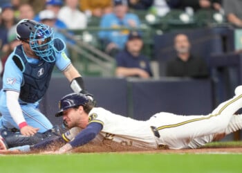 Milwaukee Brewers' Brice Turang, right, scores ahead of the tag by Toronto Blue Jays catcher Tyler Heineman, left, on a sacrifice fly hit by Luis Rengifo during the fourth inning of a baseball game, Thursday, April 16, 2026, in Milwaukee. (AP Photo/Kayla Wolf)