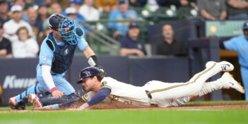 Milwaukee Brewers' Brice Turang, right, scores ahead of the tag by Toronto Blue Jays catcher Tyler Heineman, left, on a sacrifice fly hit by Luis Rengifo during the fourth inning of a baseball game, Thursday, April 16, 2026, in Milwaukee. (AP Photo/Kayla Wolf)