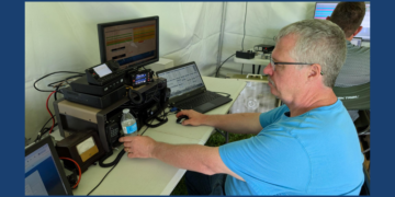 Dave Schank sits at a Ham radio setup for ARRL Field Day