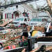 A woman walks among debris after a tornado struck Monday, July 27, 2026, in Menasha, Wis. (AP Photo/Kayla Wolf)