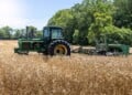 June 7, 2024- Menokin, Virginia: A John Deere farm tractor harvests golden barley in a field. (Getty Images)