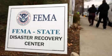 ALTADENA, CALIFORNIA - JANUARY 30: People walk past a FEMA sign following a press conference at the Altadena Disaster Recovery Center on January 30, 2025 in Altadena, California. House Democratic leaders and local officials held the press conference near the Eaton Fire burn zone to call for federal disaster assistance following the devastating wildfires in Los Angeles County. (Photo by Mario Tama/Getty Images)
