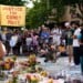 People gather near a memorial at the site where a man was shot and killed on Wednesday by Madison police, Thursday, July 23, 2026, in Madison, Wis. (AP Photo/Kayla Wolf)