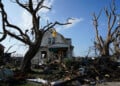 Debris is seen in front of a damaged house after a tornado struck Monday, July 27, 2026, in Menasha, Wis. (AP Photo/Kayla Wolf)