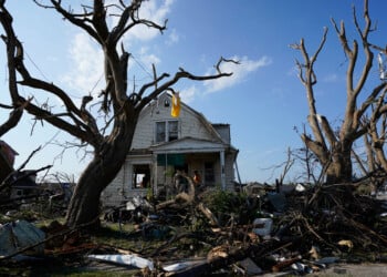 Debris is seen in front of a damaged house after a tornado struck Monday, July 27, 2026, in Menasha, Wis. (AP Photo/Kayla Wolf)