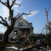 Debris is seen in front of a damaged house after a tornado struck Monday, July 27, 2026, in Menasha, Wis. (AP Photo/Kayla Wolf)