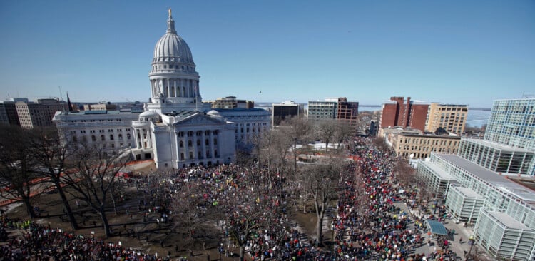 FILE - Protestors, and supporters, of Wisconsin Gov. Scott Walker's bill to eliminate collective bargaining rights for many state workers gather outside the state Capitol in Madison, Wis. on Feb. 19, 2011. (AP Photo/Andy Manis, File)