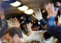 Christian Yelich high-fives his teammates in the dugout after hitting a home run at American Family Field.