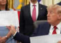 President Donald Trump holds up a chart as Arkansas Gov. Sarah Huckabee Sanders, from left, Mehmet Oz, administrator of the Centers for Medicare & Medicaid Services, and Health and Human Services Secretary Robert F. Kennedy Jr. listen during an event about healthcare in the Oval Office of the White House, Friday Sept. 18, 2026, in Washington. (AP Photo/Jacquelyn Martin)