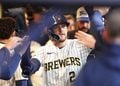 Brice Turang gets high fives in the dugout after hitting a home run at American Family Field.
