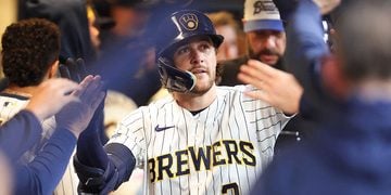 Brice Turang gets high fives in the dugout after hitting a home run at American Family Field.