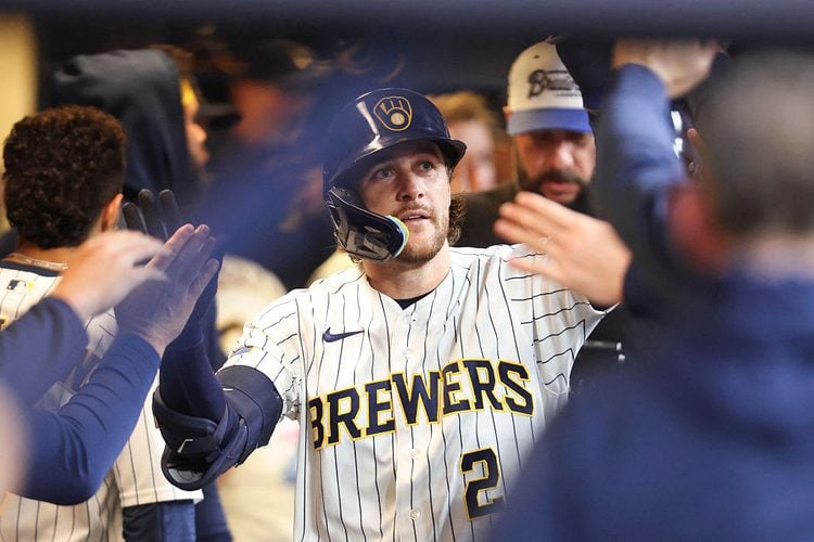 Brice Turang gets high fives in the dugout after hitting a home run at American Family Field.