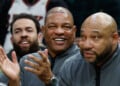 FILE - Milwaukee Bucks head coach Doc Rivers, center, applauds during the first half of an NBA basketball game against the Dallas Mavericks, March 31, 2026, in Milwaukee. (AP Photo/Jeffrey Phelps, File)