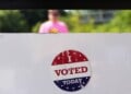 An, " I Voted Today," sticker is stuck to an information sign at Olbrich Gardens, Aug. 11, 2026, in Madison, Wis. (AP Photo/Nam Y. Huh, File)