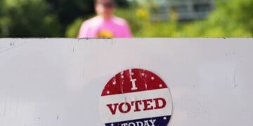 An, " I Voted Today," sticker is stuck to an information sign at Olbrich Gardens, Aug. 11, 2026, in Madison, Wis. (AP Photo/Nam Y. Huh, File)