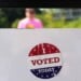 An, " I Voted Today," sticker is stuck to an information sign at Olbrich Gardens, Aug. 11, 2026, in Madison, Wis. (AP Photo/Nam Y. Huh, File)