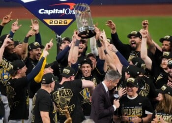 Milwaukee Brewers designated hitter Christian Yelich holds the World Series trophy with teammates after winning baseball's World Series, against the Tampa Bay Rays, Wednesday, Oct. 28, 2026, in St. Petersburg, Fla. (AP Photo/Morry Gash)