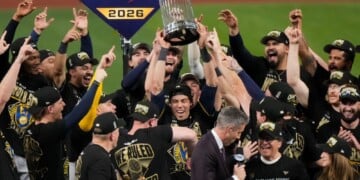 Milwaukee Brewers designated hitter Christian Yelich holds the World Series trophy with teammates after winning baseball's World Series, against the Tampa Bay Rays, Wednesday, Oct. 28, 2026, in St. Petersburg, Fla. (AP Photo/Morry Gash)